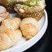 An American Metalcraft white porcelain serving plate with pastries and muffins on it.