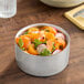 A 34 oz. hammered double wall insulated stainless steel bowl filled with a fresh salad.