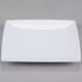 A close up of a white Thunder Group square melamine plate with a small rim.