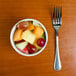 An Arcoroc Rondo bouillon cup filled with fruit on a table.