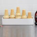 A white melamine box holding a tray of ice cream cones.