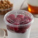 A Solo Ultra Clear PET plastic lid on a bowl of yogurt with red raspberries.