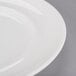 An Arcoroc white porcelain dinner plate with a rim.