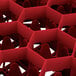 A red plastic container with hexagonal compartments.
