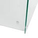A close-up of a curved glass sneeze guard with green trim.