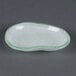 A white opal glass eliptical bowl with a green rim.