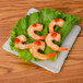 A shrimp on a 10 Strawberry Street Izabel Lam opal glass square plate with lettuce.