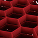 A red Vollrath Traex glass rack with hexagonal compartments.