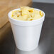 A white 16 oz. foam food container filled with a creamy pasta dish.