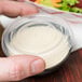 A hand holding a Solo plastic container with a salad in it with a Solo Snaptight lid on it.