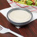A bowl of salad with a fork and a Solo plastic container with a lid.