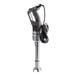 A compact immersion blender with a black handle and a metal blending shaft, featuring an attached power cord.