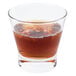 An Arcoroc Shetland Rocks glass filled with brown liquid, ice, and berries.