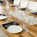 A table set with 10 Strawberry Street white porcelain plates and glasses.