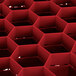 A red Vollrath Traex rack with hexagonal compartments.