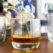 A brown liquid being poured into an Arcoroc Cabernet rocks glass.