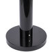 A close-up of a black cylindrical Rubbermaid cigarette receptacle.