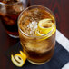 Two Arcoroc Cabernet cooler glasses of iced tea with lemon and ice on a table.