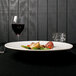 A plate of food on a table with a glass of wine.