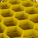 A yellow Vollrath Traex glass rack with many compartments.