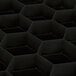 A black plastic Vollrath Traex glass rack with hexagon compartments.