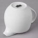 A white porcelain creamer with a handle.