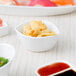 A table with a variety of food in 10 Strawberry Street white porcelain leaf bowls.