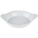 A white shirred egg dish with a handle.