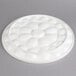 A white porcelain circular platter with a flower design.