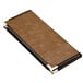 A brown leather Menu Solutions Royal Select menu cover with black corners on a table in a bar.