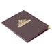 A brown leather Menu Solutions Royal Select menu cover with a gold logo on a table.