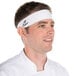 A man wearing a white Headsweats headband on his head.