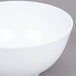 A white GET Water Lily melamine bowl on a gray surface.