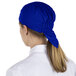 A woman wearing a royal blue Headsweats chef cap.