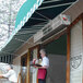 A woman in a white shirt uses a Curtron air curtain to serve food to a man at a farm-to-table restaurant.