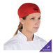 A woman wearing a red customizable shorty chef cap.