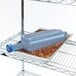 A blue San Jamar Rapi-Kool cooling paddle in a container of food on a counter.