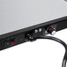 A close-up of a black and silver electrical box with a black power cord.