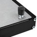 A black metal box with a metal base and a knob on top.