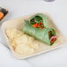 An Eco-gecko square palm leaf plate with food on it on a table.