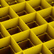 A close up of a Vollrath yellow glass rack grid with many squares.