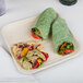 A Eco-gecko palm leaf plate with salad on a white surface.