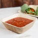 A white table with Eco-gecko palm leaf bowls of tomato sauce and burritos.