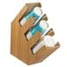 A Cal-Mil bamboo countertop cup and lid organizer with three sections holding white plastic cups.