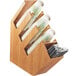 A wooden Cal-Mil countertop organizer with cups and a straw.