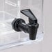 A clear plastic beverage dispenser with black spigot handles.