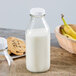 A Libbey glass milk bottle next to a plate of cookies.