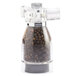 A Chef Specialties acrylic pepper mill with black peppercorns inside.
