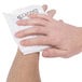 A person's hand holding a white Medique instant ice pack.