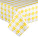 A yellow and white checkered Intedge vinyl table cover on a table.